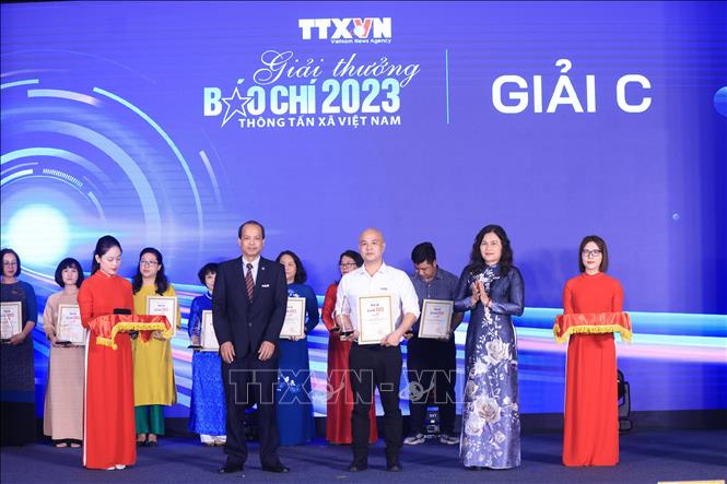 Phó Tổng giám đốc TTXVN Nguyễn Thị Sự và Trưởng Ban biên tập Ảnh Nguyễn Quang Hải trao giải C cho các tác giả, nhóm tác giả đạt giải. Ảnh: Tuấn Anh - TTXVN