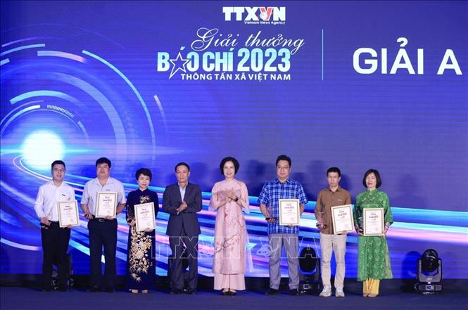 Tổng giám đốc TTXVN Vũ Việt Trang và Phó Chủ tịch thường trực Hội Nhà báo Việt Nam Nguyễn Đức Lợi trao giải A cho các tác giả, nhóm tác giả đạt giải. Ảnh: Tuấn Anh - TTXVN